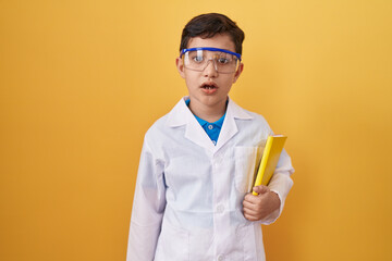 Little hispanic boy wearing scientist glasses scared and amazed with open mouth for surprise,...