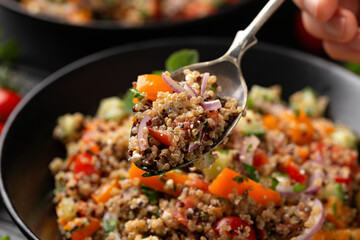 Red and white quinoa tabbouleh salad with tomatoes, paprika and mint. Vegetarian, vegan food concept