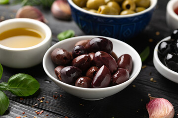 Assortment of fresh green, kalamata and black olives in bowl. Healthy snack