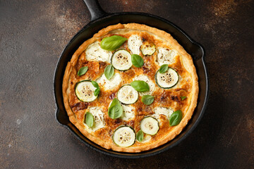 Sun baked tomato, goats cheese and courgette quiche served in cast iron pan with side salad