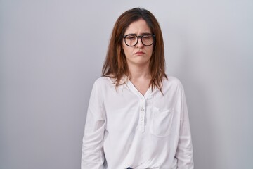 Brunette woman standing over white isolated background skeptic and nervous, frowning upset because of problem. negative person.