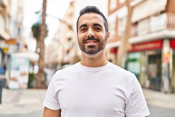 Obraz premium Young hispanic man smiling confident standing at street