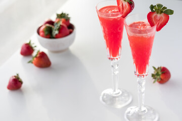 Refreshing strawberry mimosas with a bowl of strawberries.