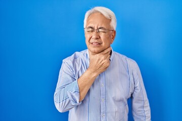 Hispanic senior man wearing glasses touching painful neck, sore throat for flu, clod and infection
