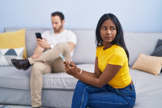 Man and woman interracial couple with problem using smartphone at home