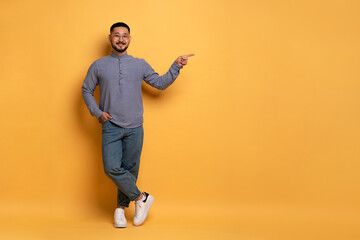 Check This. Happy Asian Man Pointing Aside At Copy Space With Hand