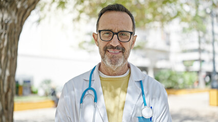 Middle age man doctor smiling confident standing at park