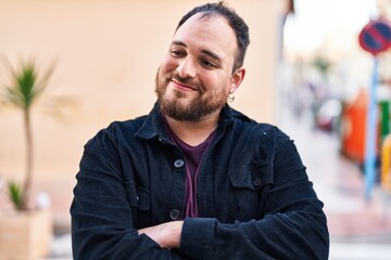 Young hispanic man smiling confident standing with arms crossed gesture at street