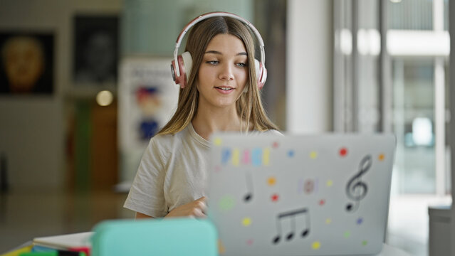 Young beautiful girl student having video call at library
