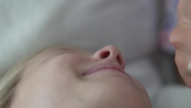 Close-up, a woman instills drops in the nose of a little girl