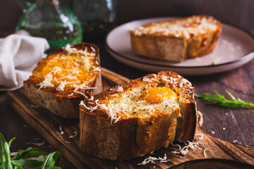Bread baked with egg and cheese on a cutting board
