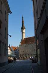 Fototapeta premium A side street view looking onto Tallinn market square and Tallinn city hall on a summers evening - June 2023