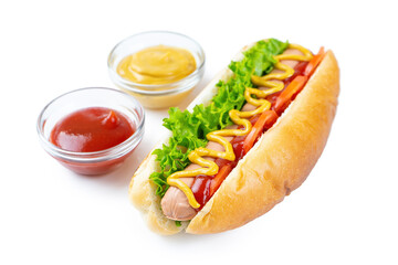 Homemade Hot Dog with yellow mustard, ketchup, tomato and fresh salad leaves isolated on white background. Fast food, street food, american cuisine