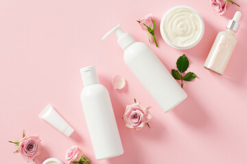 Set of natural organic cosmetics with rose petals on pink background