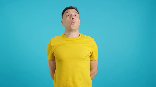 A caucasian casual man standing whistling absent-mindedly