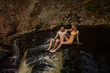 Beautiful couple in waterfall, girl and guy