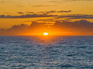 Sun rising on the horizon over the ocean