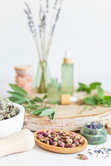 Botanical blends, rose buds, herbs, essencial oils for naturopathy. Natural remedy, herbal medicine, blends for bath and tea on wooden table background