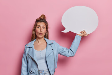 Photo of surprised European woman stares impressed at camera stands speechless wears blue jacket...