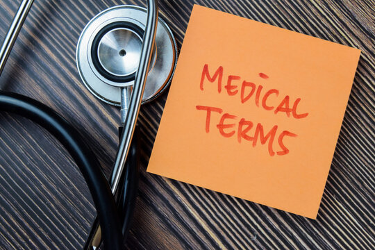 Concept of Medical Terms write on sticky notes with stethoscope isolated on Wooden Table.