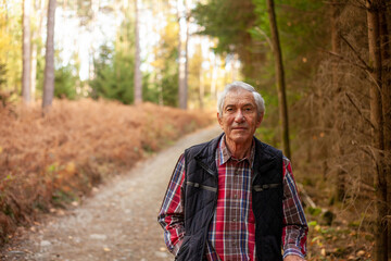 Naklejka na ściany i meble Portrait of an elderly man in a forest. Selective focus.