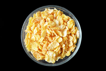Bowl of cornflakes isolated on black background