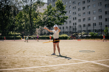 Obraz premium girl twists a hoop, school lesson physical education, outdoor sports