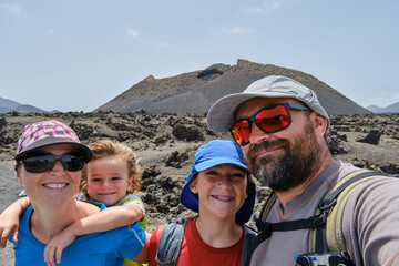 Family taking a selfie while hiking between volcanoes. El Cuervo volcano in the background....