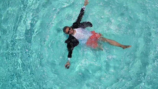 Excited businessman in wet suit swim in sea pool water. Funny businessman, comic business. Crazy summer business. Fun summer business lifestyle funny businessman. Excited dancing business man in pool.