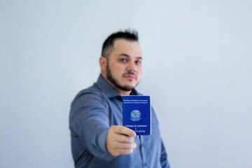 confident man showing his work brazilian document carteira de trabalho blurred background