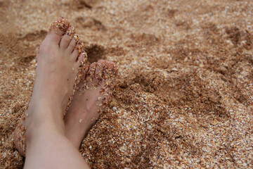 Bare feet in the sand, seashore, relaxation on the beach
