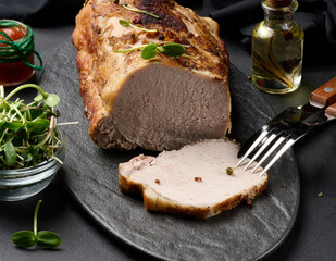 Baked piece of pork balyk on the table with spices. Tenderloin cut into pieces