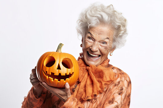 Smiling older woman wearing festive Halloween orange clothes holding a smiling carved pumpkin with copy space  created with Generative AI technology