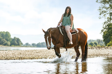 Equestrian and horse cooling down at a hot summer day: A young woman and her bay brown andalusian x...