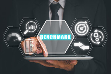 Benchmarking concept, Businessman hand touching on tablet computer with benchmarking icon on...