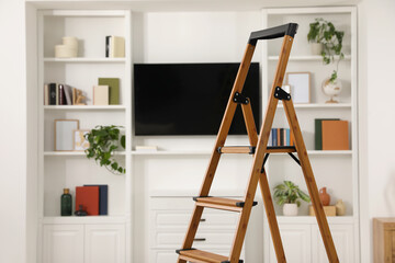 Wooden folding ladder in stylish living room