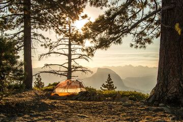 Tent at sunrise in Yosemite with Half Dome in distance from on top of El Capitan