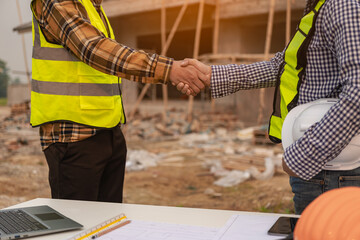 A team of construction workers greeted the plan to start a new project contract in the office center at the construction site, concepts, partners and contractors in real estate.