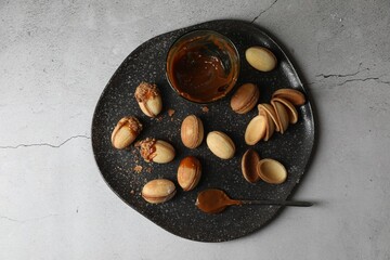 Delicious walnut shaped cookies with condensed milk on grey table, top view