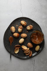 Delicious walnut shaped cookies with condensed milk on grey table, top view