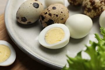 Unpeeled and peeled hard boiled quail eggs on plate, closeup