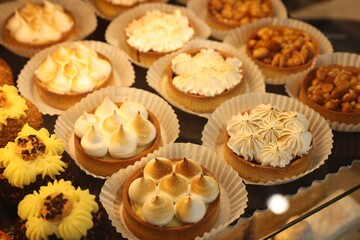 Fototapeta na wymiar Different tasty tartlets on counter in bakery shop, closeup