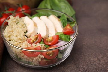 Delicious quinoa salad with chicken and cherry tomatoes served on grey textured table, closeup