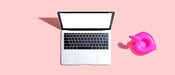 Laptop computer with a pink flamingo - flat lay © Tierney