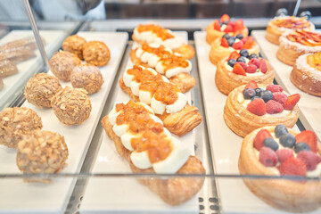 fresh pastries with berries. A variety of fresh pastries in the bakery window. almond croissant is fresh and hot in a cafe next to other types of pastries. The interior of an Italian restaurant.