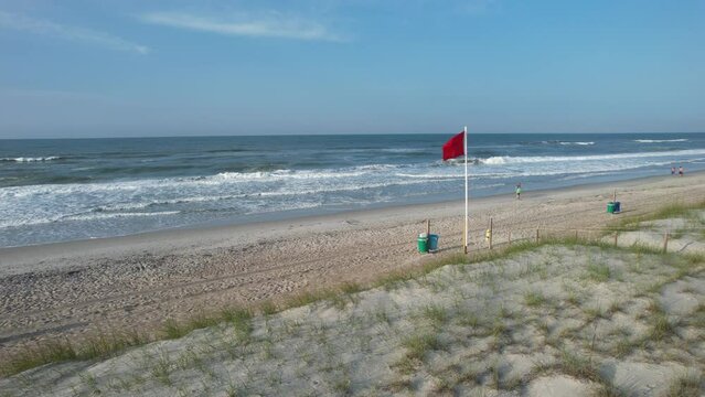 Shot of Red Flag on the beach with ocean in the background