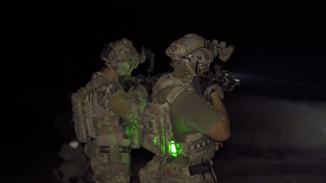 Team of U.S. Army marine corps soldier military war at night mission with gun participating and preparing to attack the enemy in Thailand during Exercise Cobra Gold in battle. Combat force training.