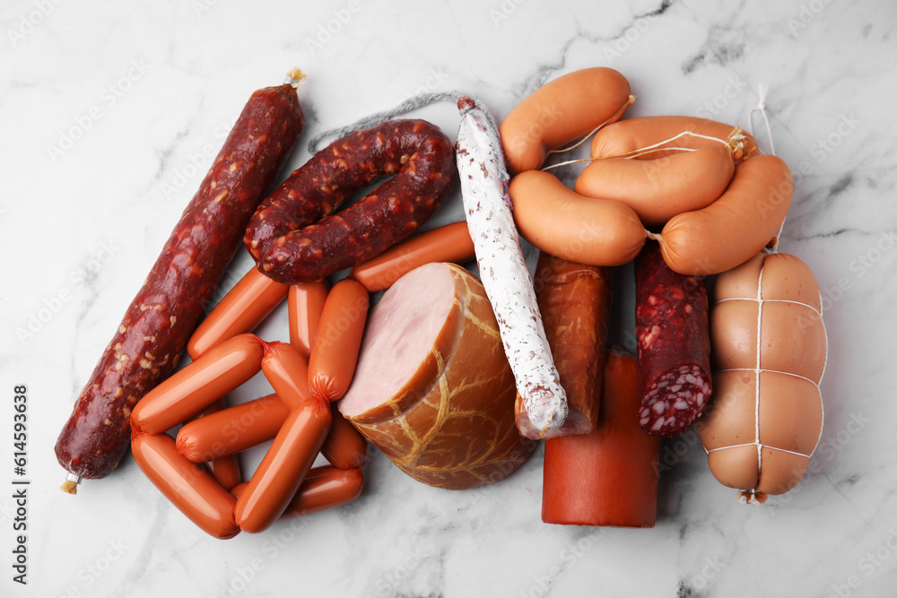 Wall mural different types of sausages on white marble table, flat lay