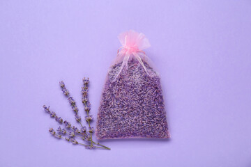 Scented sachet with dried lavender flowers on lilac background, flat lay