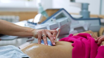 Ultrasound transducer is slowly moved by the pregnant belly of a patient. Intrauterine development of a baby check up.